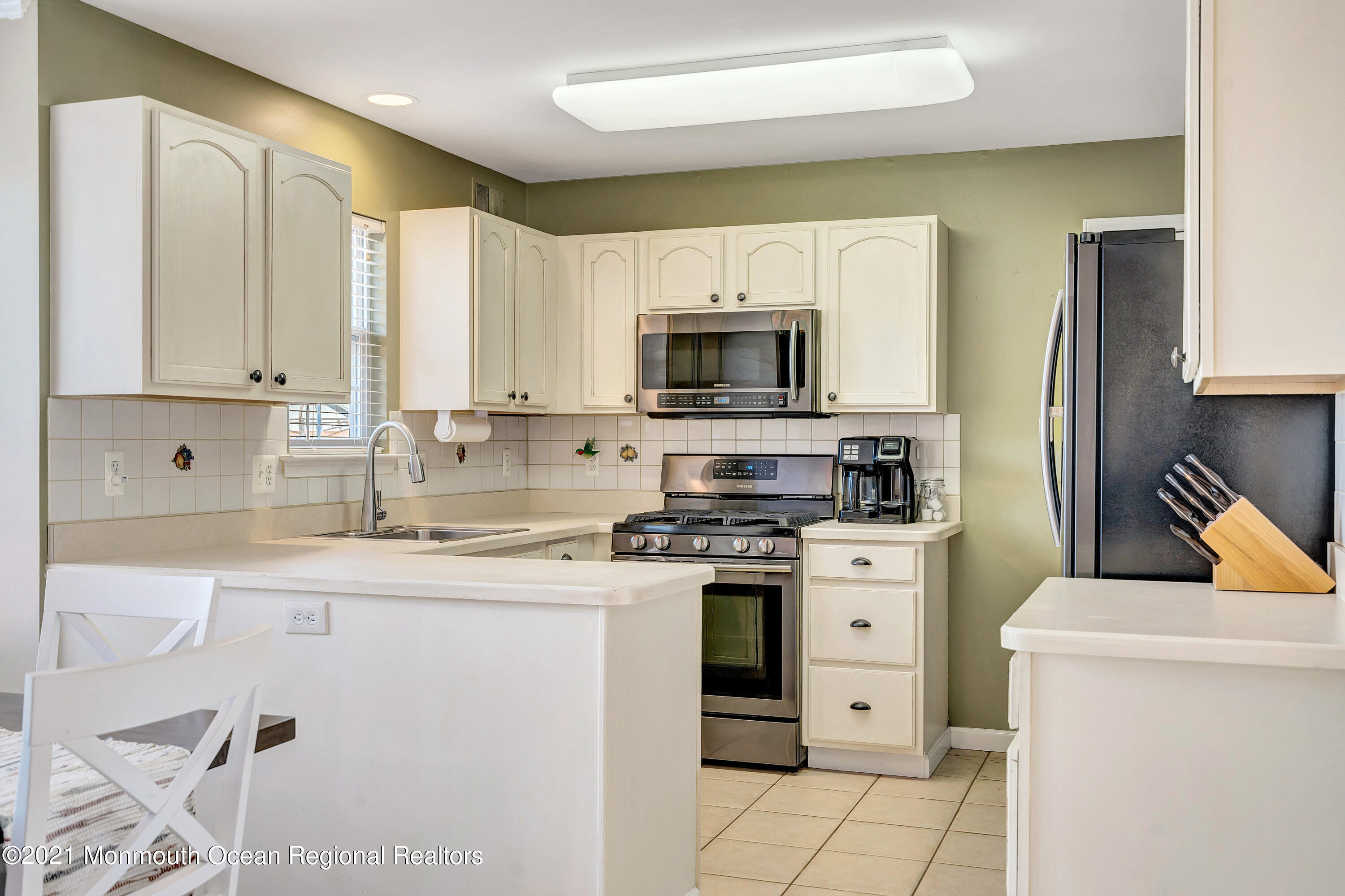 101 Longboat Road Manahawkin, NJ 08050 - Photo 17 of 47 a kitchen with a stove a sink a microwave a refrigerator and cabinets