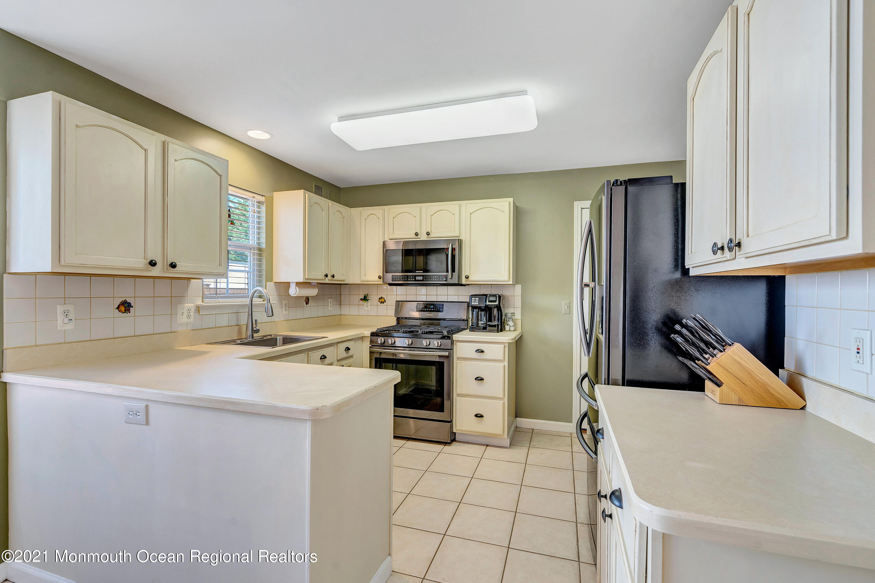 101 Longboat Road Manahawkin, NJ 08050 - Photo 19 of 47 a kitchen with a sink a stove top oven and white cabinets