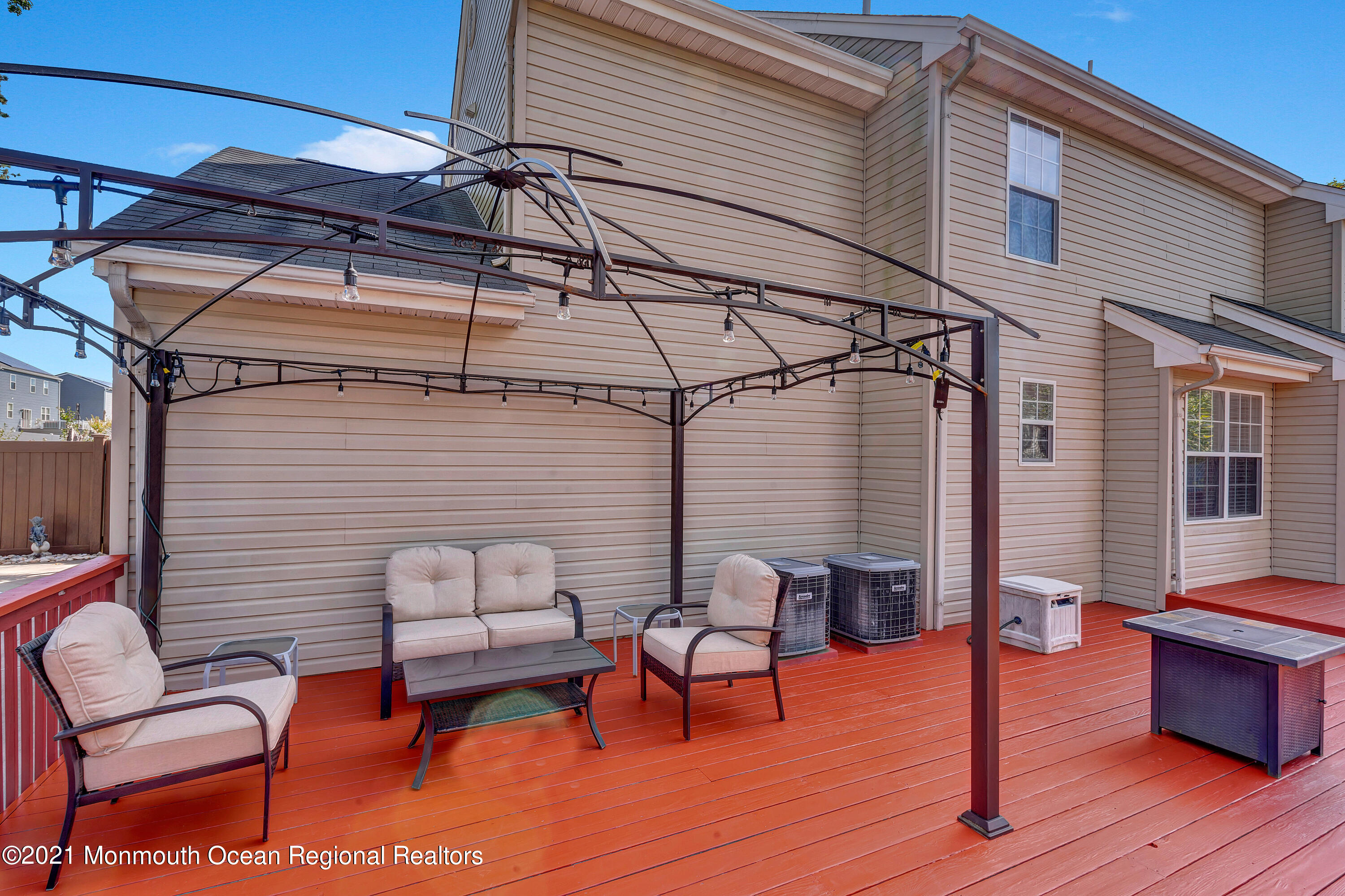 101 Longboat Road Manahawkin, NJ 08050 - Photo 34 of 47 a view of a patio with table and chairs with wooden floor and fence