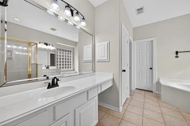 a bathroom with a sink a large mirror and a bathtub