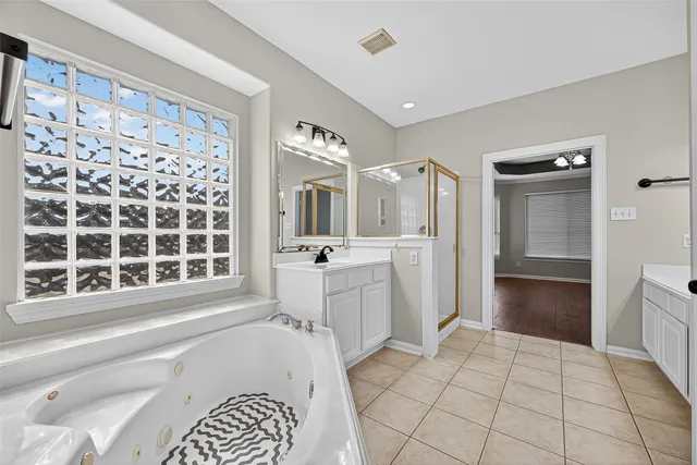 a bathroom with a sink a large mirror and a bathtub