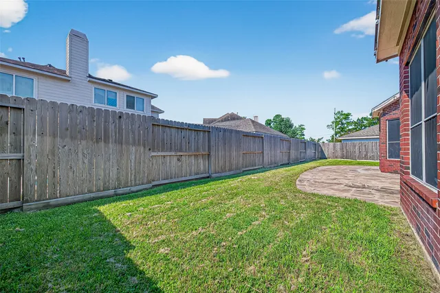 a view of a backyard with a barbeque and wooden fence