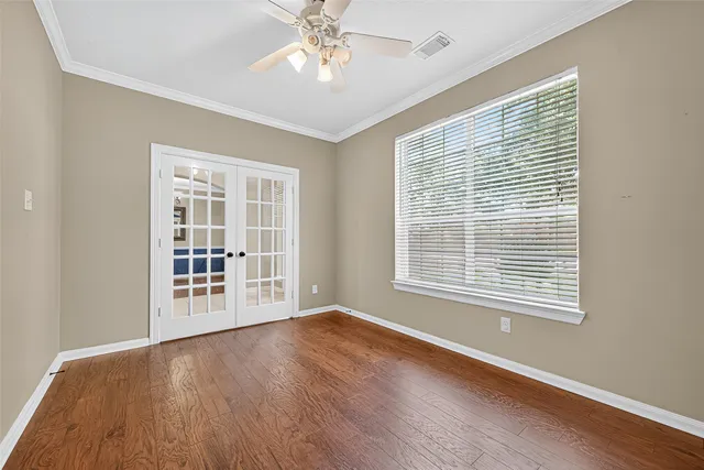 a view of an empty room with a window and wooden floor