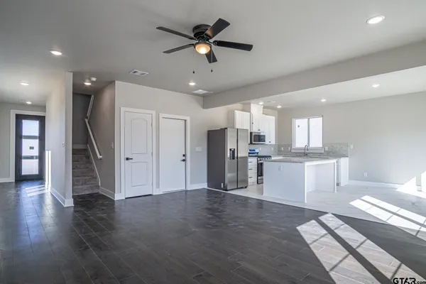 a view of a kitchen with wooden floor and a ceiling fan