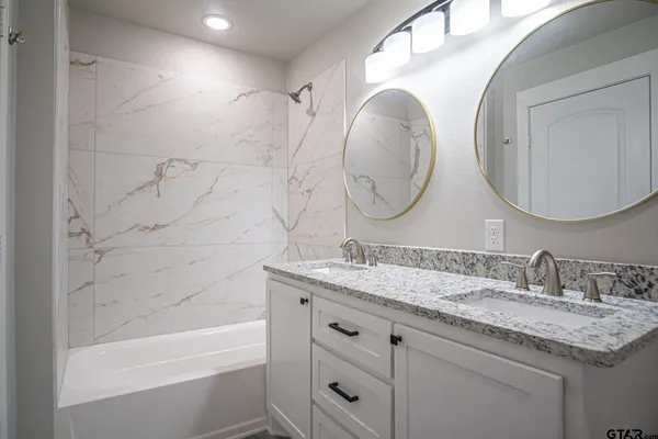 a bathroom with a granite countertop sink toilet and a mirror