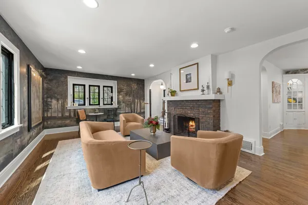 a kitchen with stainless steel appliances granite countertop a refrigerator a stove a sink dishwasher and a dining table with wooden floor