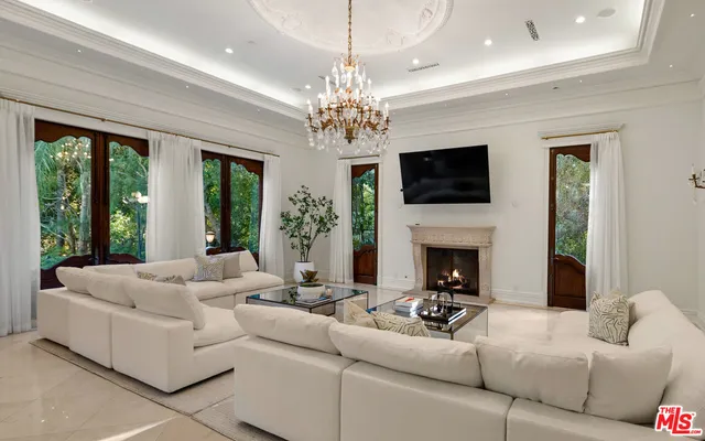 a living room with furniture a fireplace and a chandelier