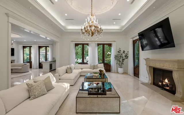 a living room with furniture a fireplace and a chandelier