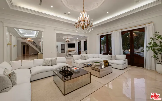 a living room with furniture and a chandelier