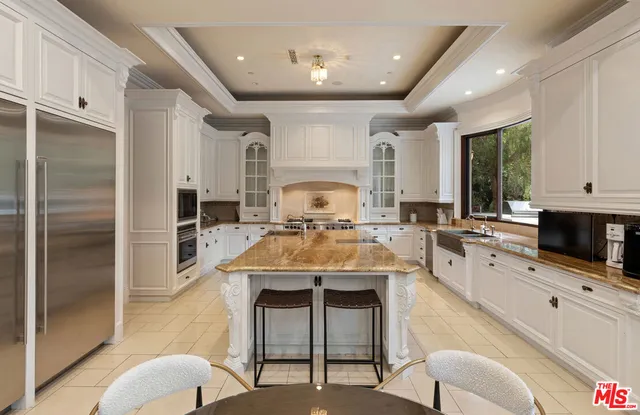 a large kitchen with kitchen island a large counter top space appliances and cabinets
