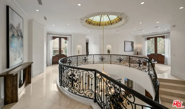 a view of a hallway with a chandelier and furniture