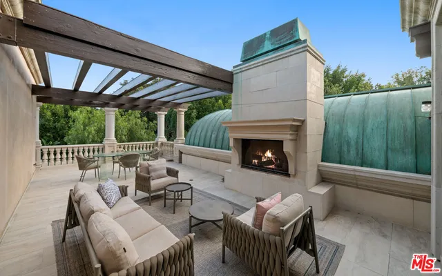 a outdoor space with patio couch and a fireplace