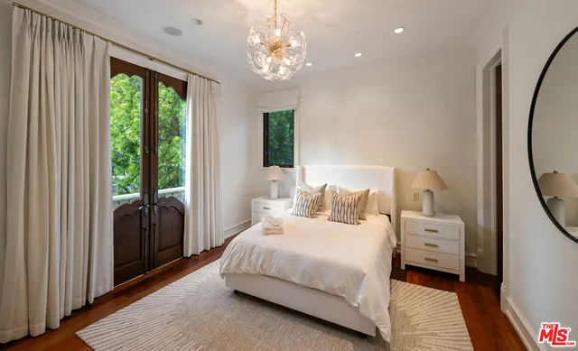 a bedroom with a large bed and a chandelier