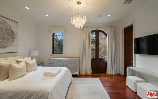 a bedroom with a bed and a large window