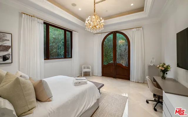 a bedroom with a bed and a chandelier