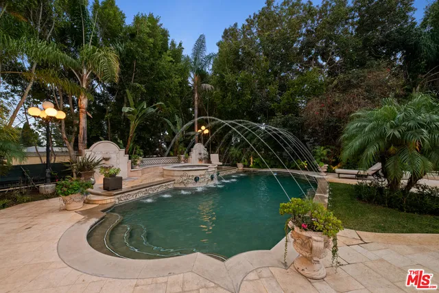 a view of a swimming pool with a patio and garden