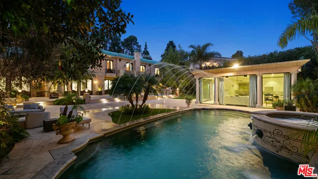 a view of a house with swimming pool and sitting area