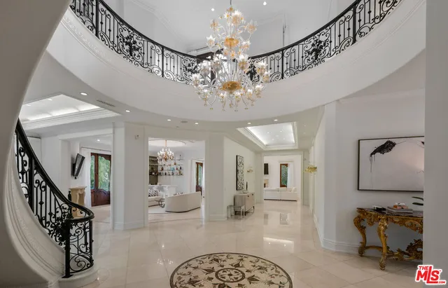 a view of a hallway with a livingroom and chandelier