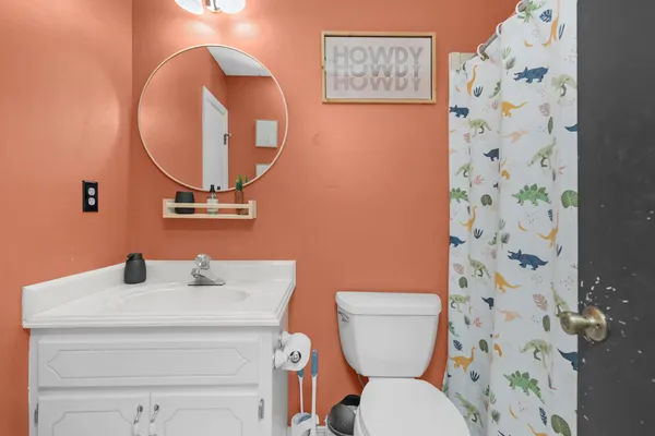 a bathroom with a toilet a sink and a mirror