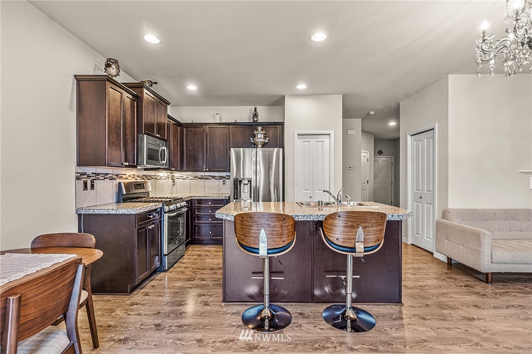 3627 202nd Pl S East Bothell, WA 98012 - Photo 13 of 38 a kitchen with kitchen island granite countertop wooden cabinets and stainless steel appliances