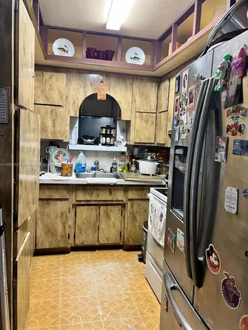 a kitchen with stainless steel appliances granite countertop a sink and wooden cabinets