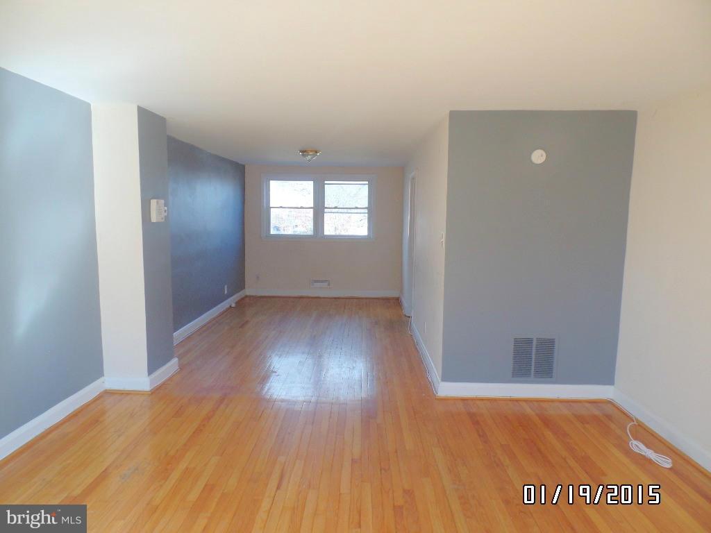 1221 Harwall Road Baltimore, MD 21207 - Photo 2 of 10 an empty room with wooden floor and windows