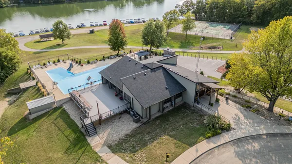 an aerial view of a house with swimming pool and outdoor seating