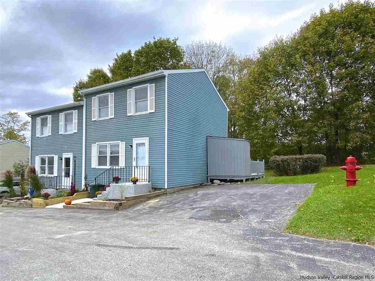 96 Rinaldi Boulevard Poughkeepsie, NY 12601 - Photo 22 of 23 a view of a white house with a yard and a table and chairs under an umbrella