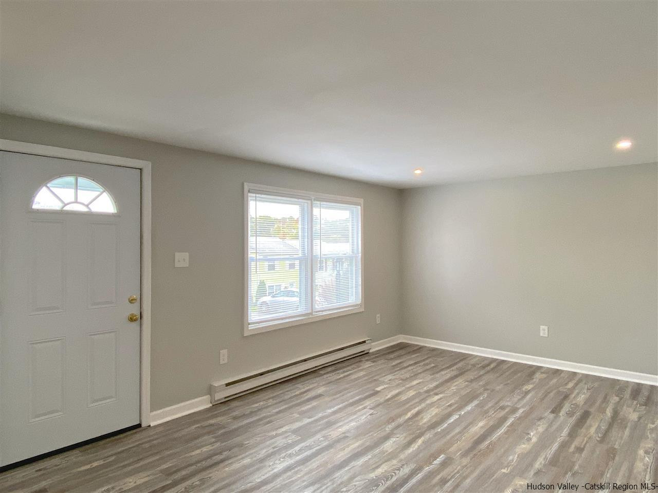 96 Rinaldi Boulevard Poughkeepsie, NY 12601 - Photo 3 of 23 an empty room with wooden floor and windows