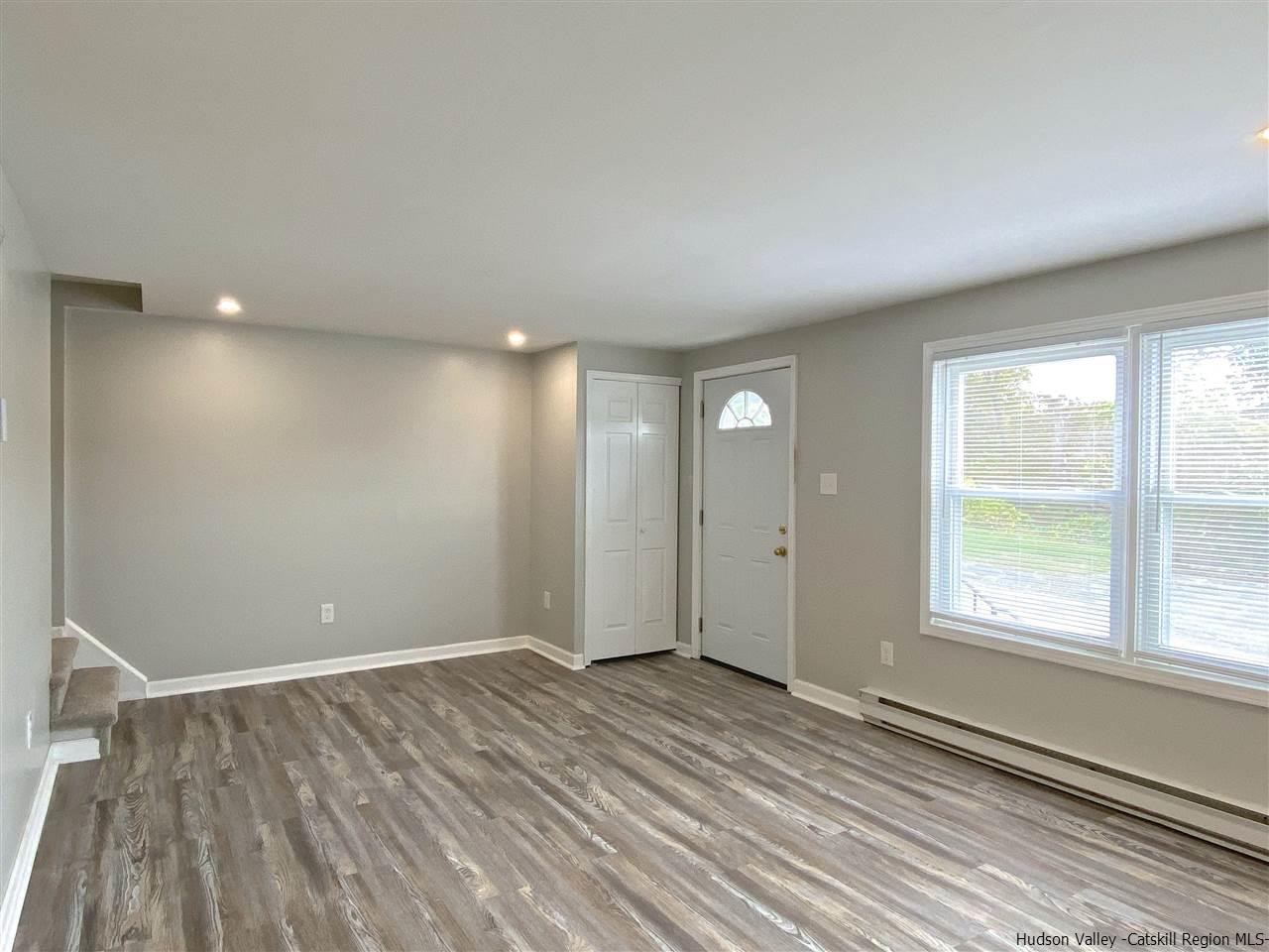 96 Rinaldi Boulevard Poughkeepsie, NY 12601 - Photo 4 of 23 an empty room with wooden floor and windows