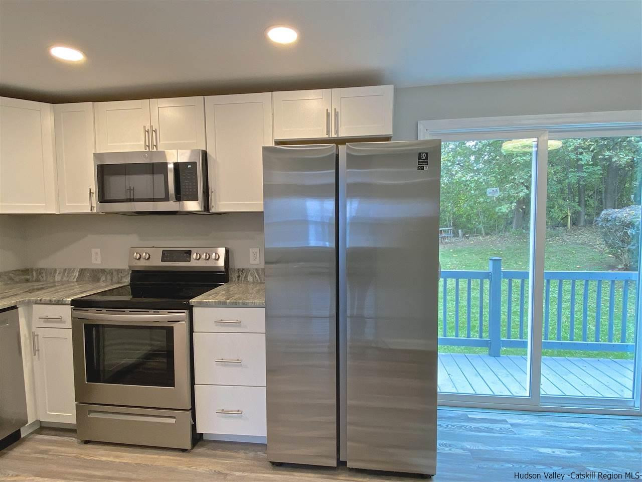 96 Rinaldi Boulevard Poughkeepsie, NY 12601 - Photo 8 of 23 a kitchen with a stove a microwave and a refrigerator