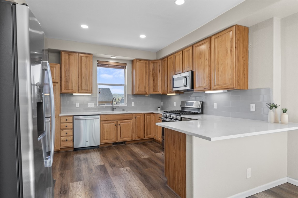324 Little Bend Road Hayden, CO 81639 - Photo 8 of 35 a kitchen with stainless steel appliances granite countertop a stove a sink dishwasher and a refrigerator with wooden floor