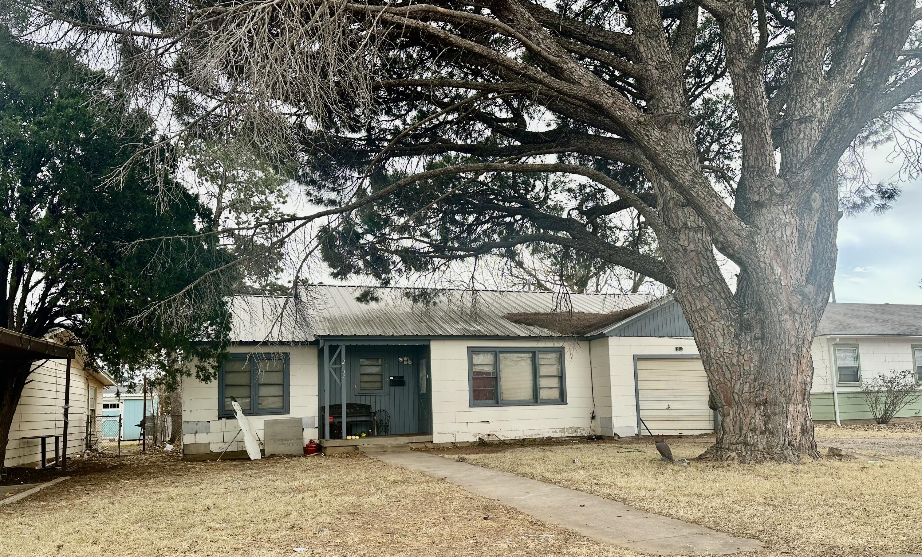 a front view of a house with a tree