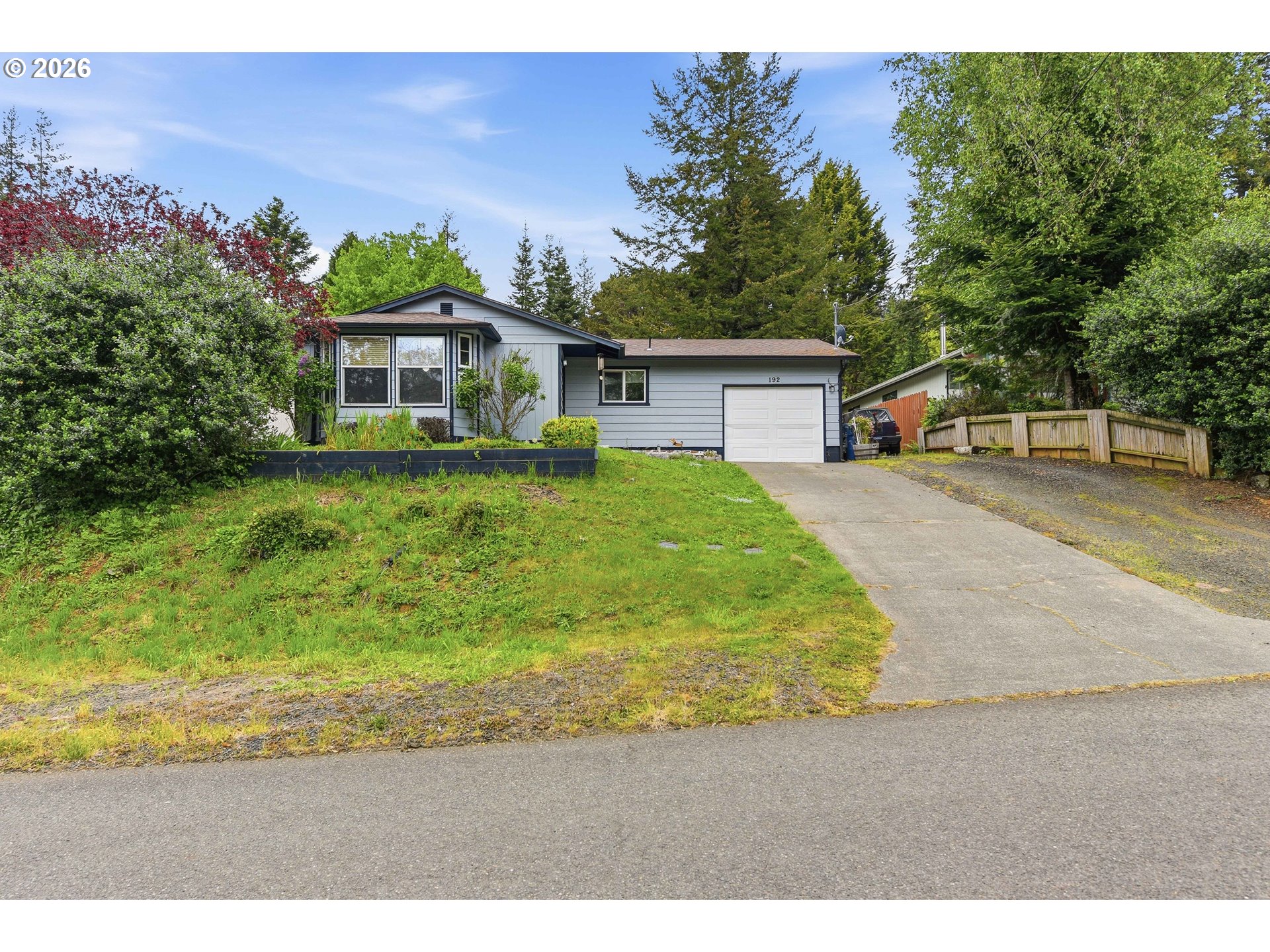 192 North Wood Ridge Road Coquille, OR 97423 - Photo 2 of 42 a front view of a house with a garden