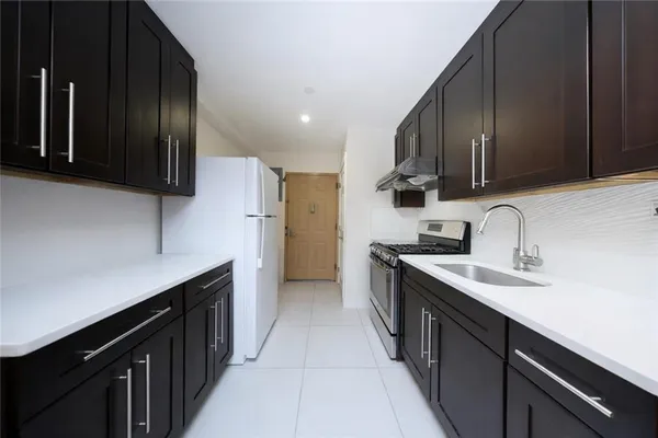 a kitchen with stainless steel appliances a sink stove top oven and refrigerator