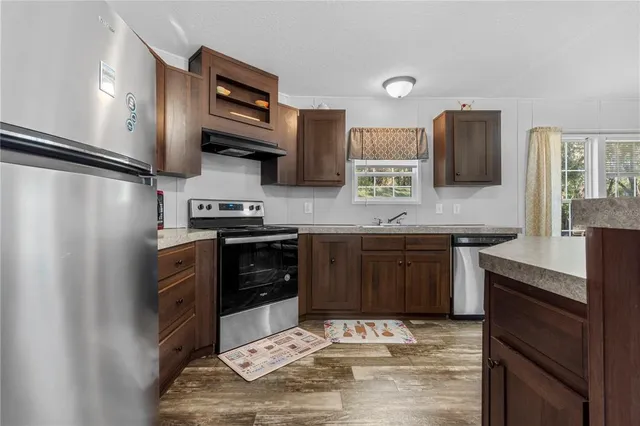 a kitchen with stainless steel appliances kitchen island granite countertop a refrigerator stove microwave and sink
