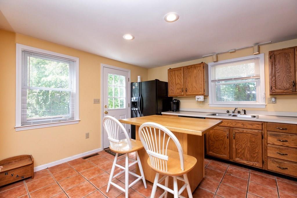 57 Christopher Road Rowley, MA 01969 - Photo 3 of 19 a dining hall with stainless steel appliances granite countertop a stove a sink dishwasher a dining table and chairs with wooden floor