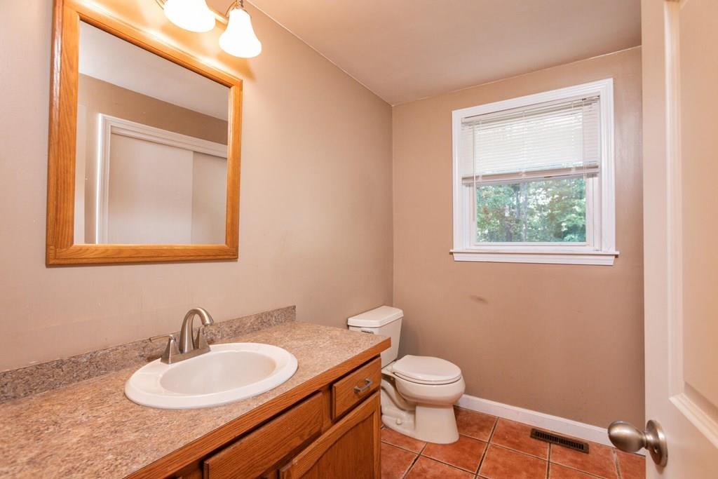 57 Christopher Road Rowley, MA 01969 - Photo 9 of 19 a bathroom with a toilet a sink a mirror and a window