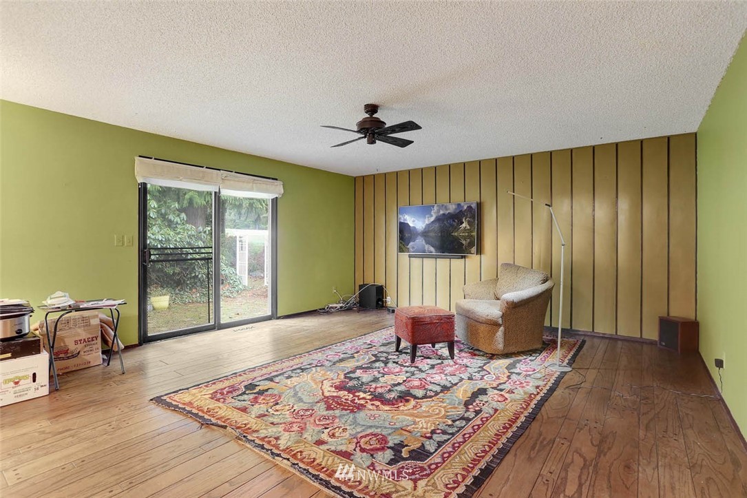 14811 Southeast 172nd Place Renton, WA 98058 - Photo 7 of 24 a living room with a couch dining table wooden floor and a large window