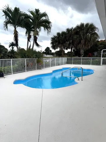 a view of a house with pool and a yard