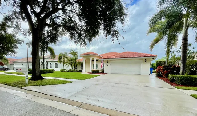 a front view of a house with a garden and trees