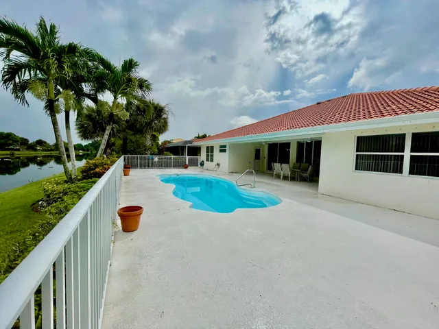 a view of an house with swimming pool and sitting area
