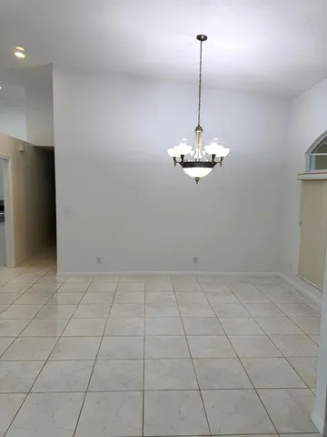 a view of a room with window and chandelier fan