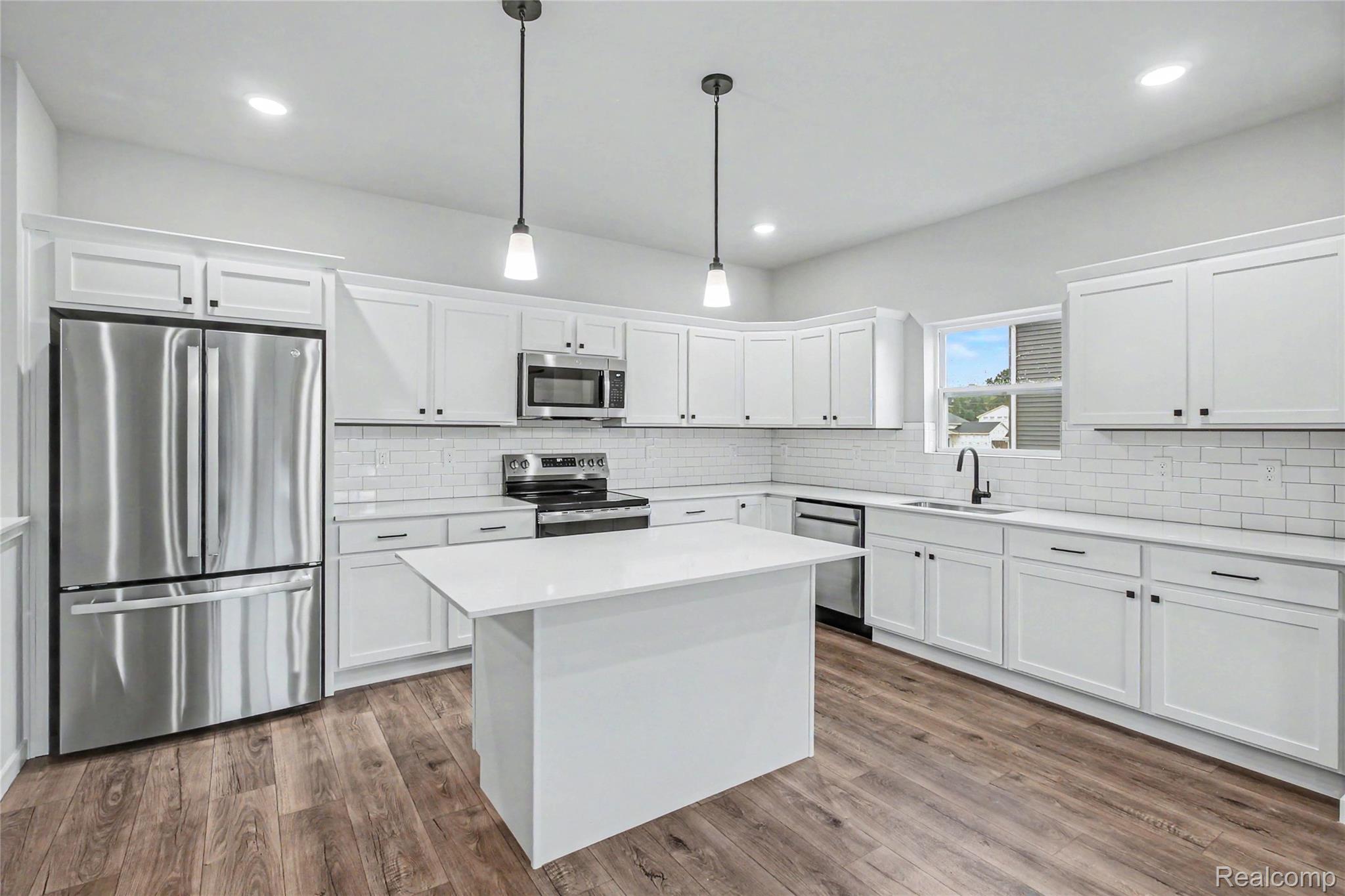 1210 Lockes Street Howell, MI 48843 - Photo 4 of 37 The kitchen includes Quartz counters with subway tile backsplash, large center island with extended edge counter and pendant lighting above. Stainless steel appliances are included!
