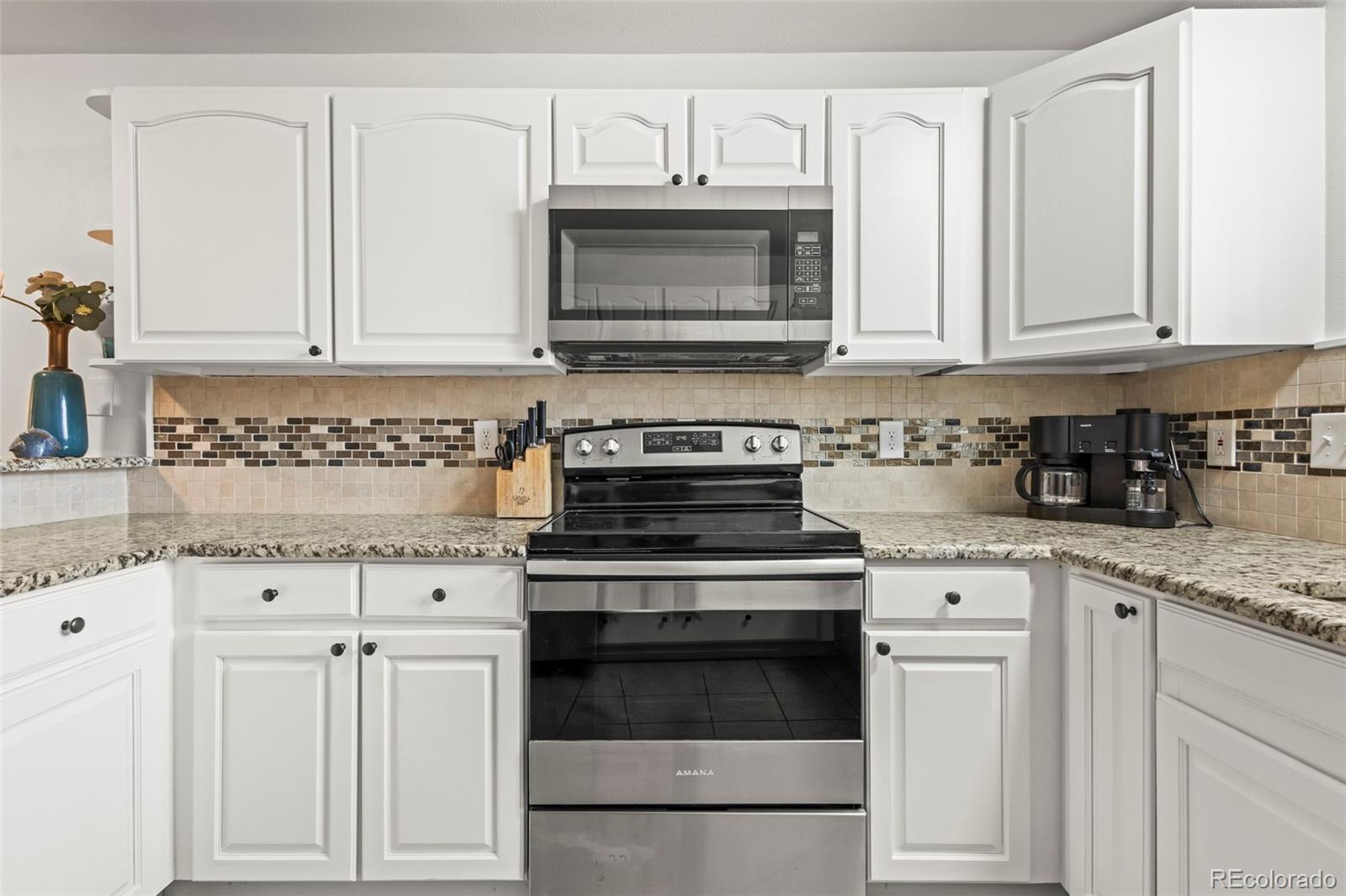 8450 Decatur Street, Unit 98 Westminster, CO 80031 - Photo 12 of 23 a kitchen with white cabinets and appliances