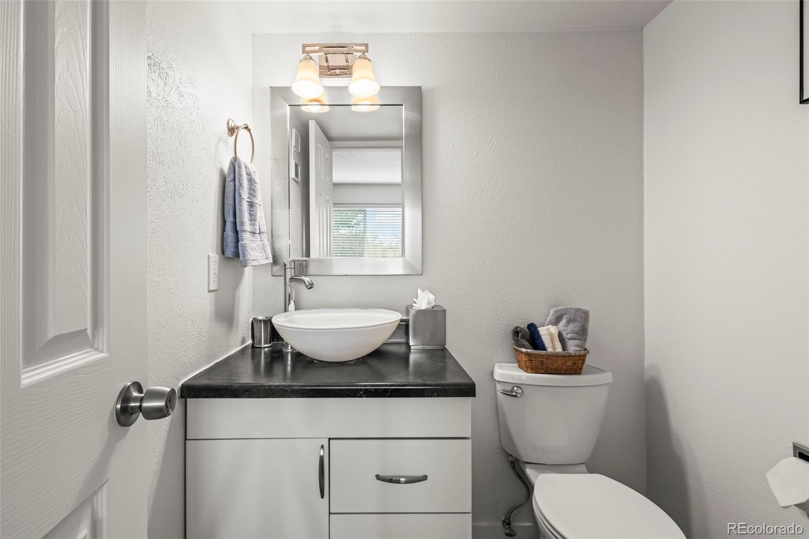 8450 Decatur Street, Unit 98 Westminster, CO 80031 - Photo 15 of 23 a bathroom with a granite countertop toilet sink and mirror