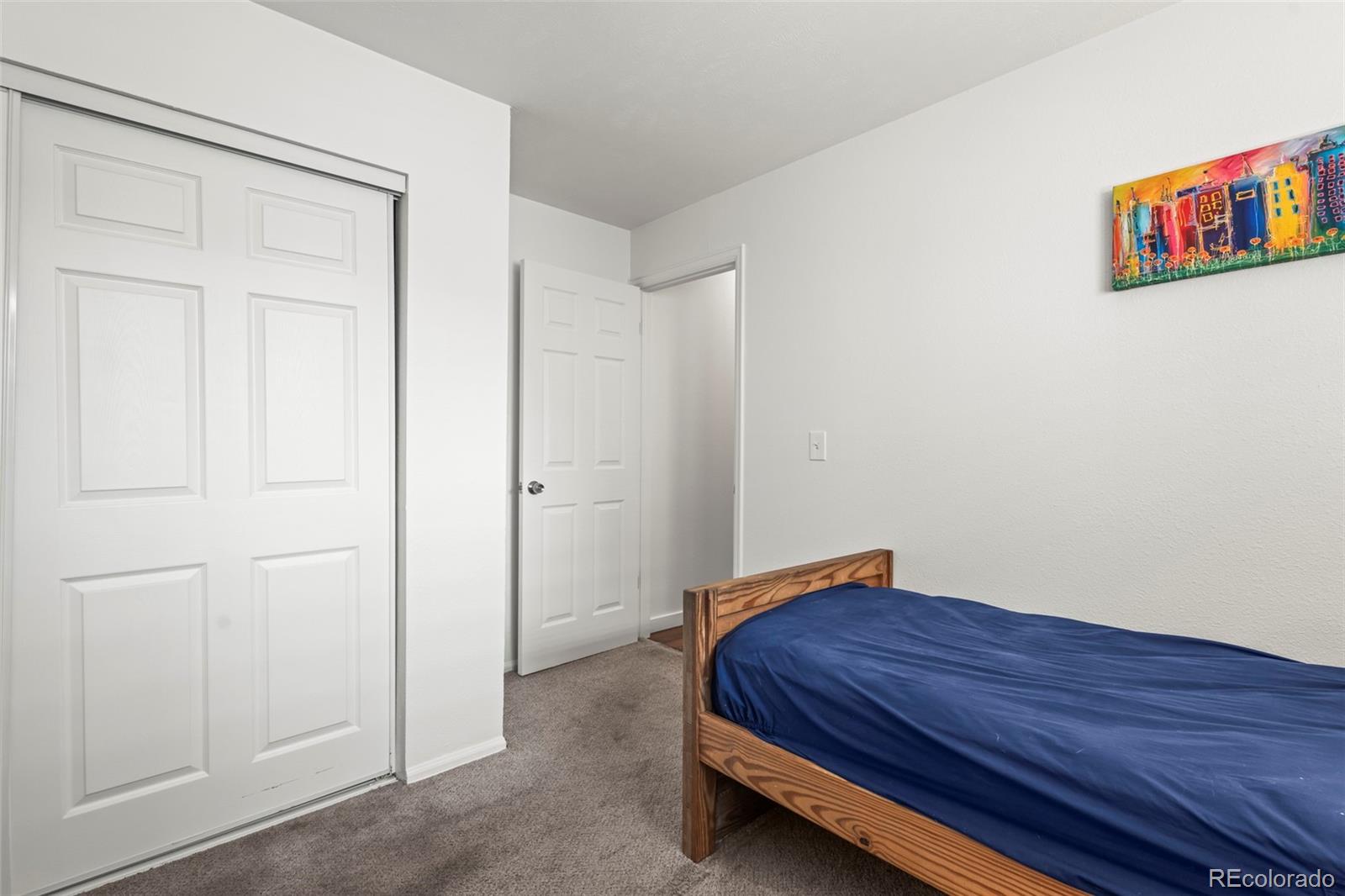 8450 Decatur Street, Unit 98 Westminster, CO 80031 - Photo 17 of 23 a bedroom with a bed and a painting on the wall