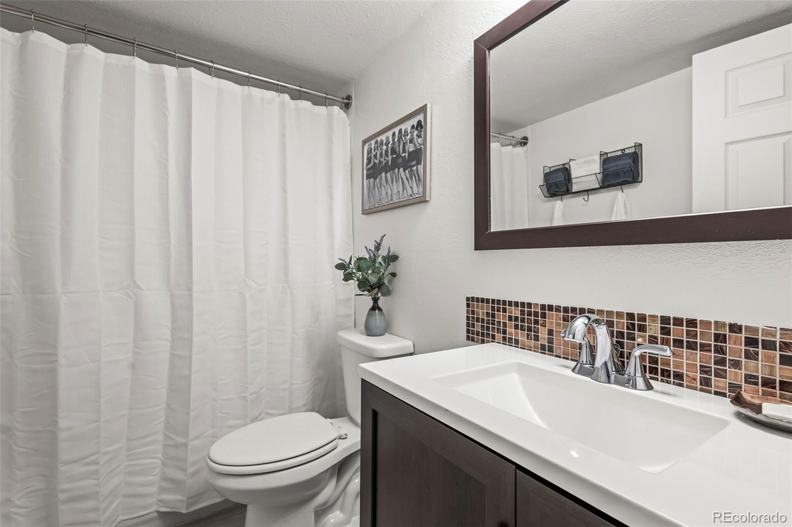 8450 Decatur Street, Unit 98 Westminster, CO 80031 - Photo 18 of 23 a bathroom with a sink a toilet and a mirror
