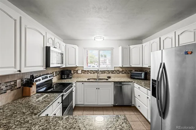 a kitchen with a sink stove and refrigerator