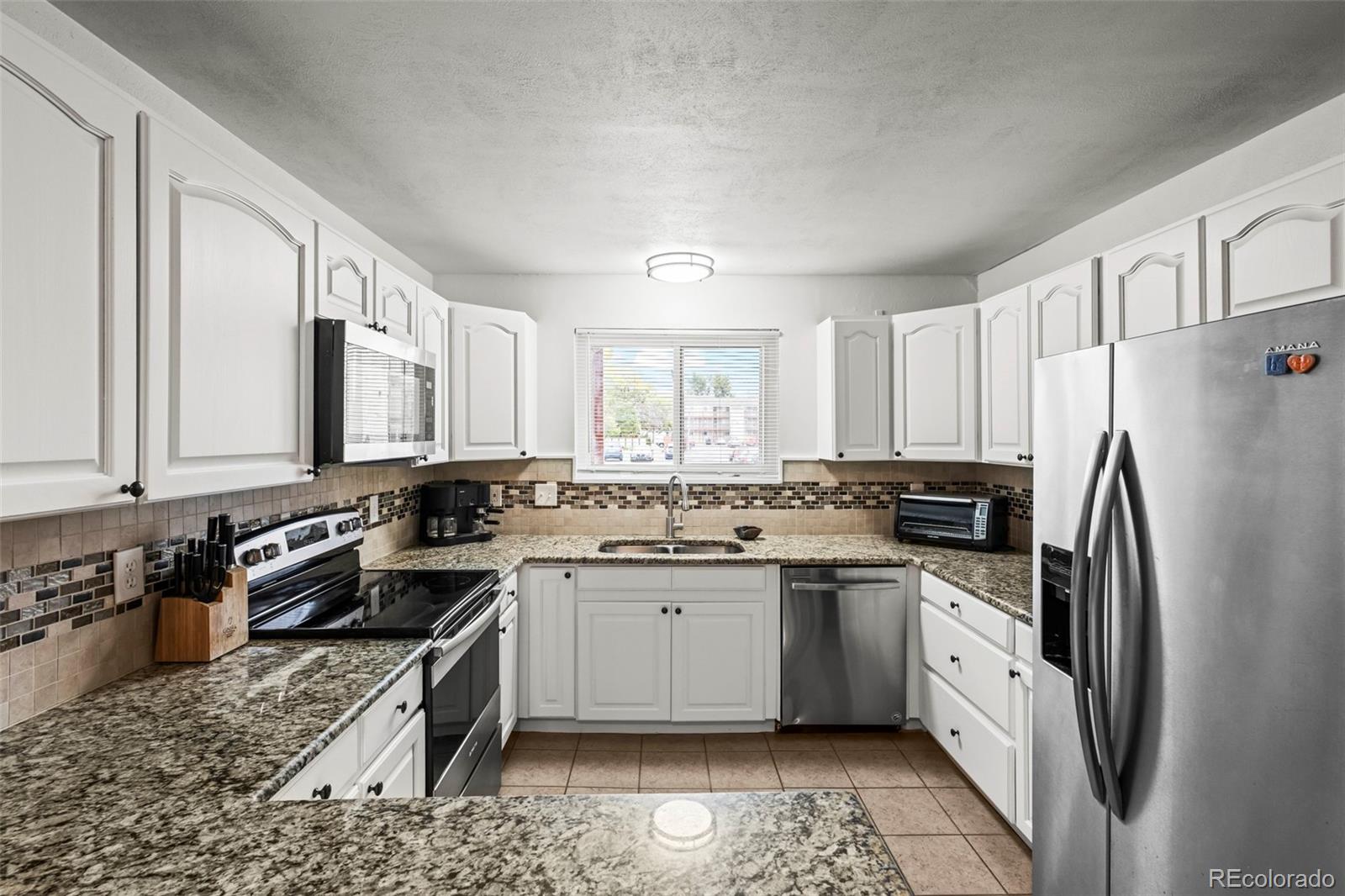 8450 Decatur Street, Unit 98 Westminster, CO 80031 - Photo 9 of 23 a kitchen with a sink stove and refrigerator
